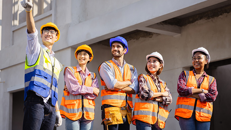 Diverse team of professionals use tablet computers on a construction site.